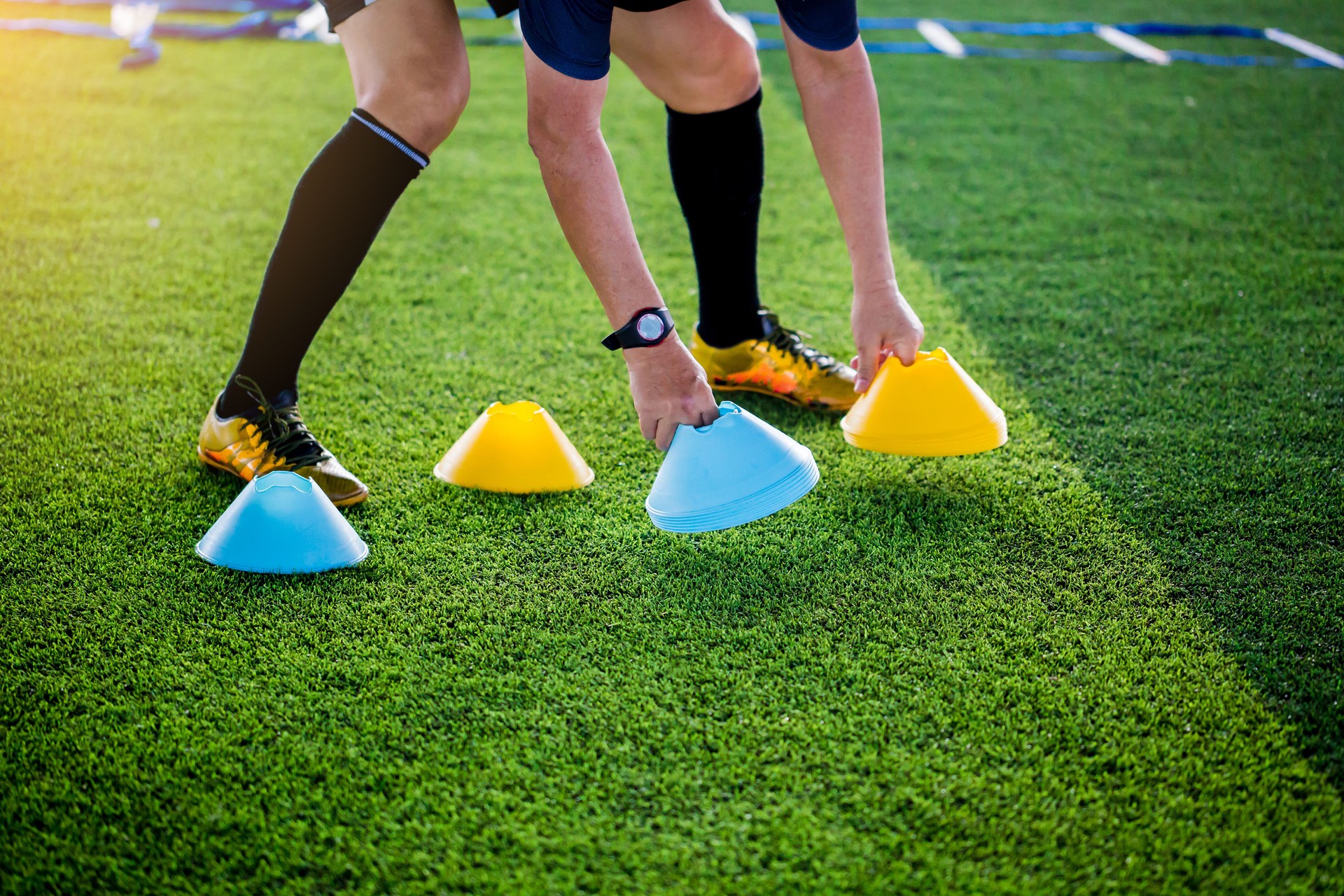 Coach is putting the marker cones for soccer training to run and jump.
